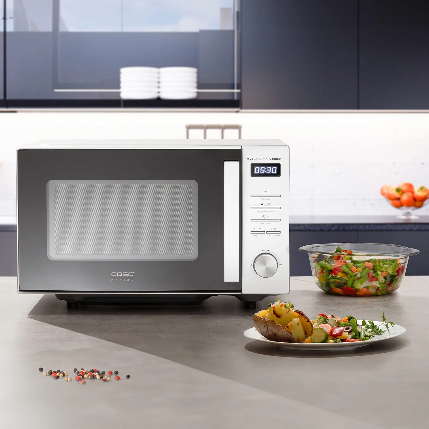 Microwave with food on a table in a kitchen with vegetables and a plate