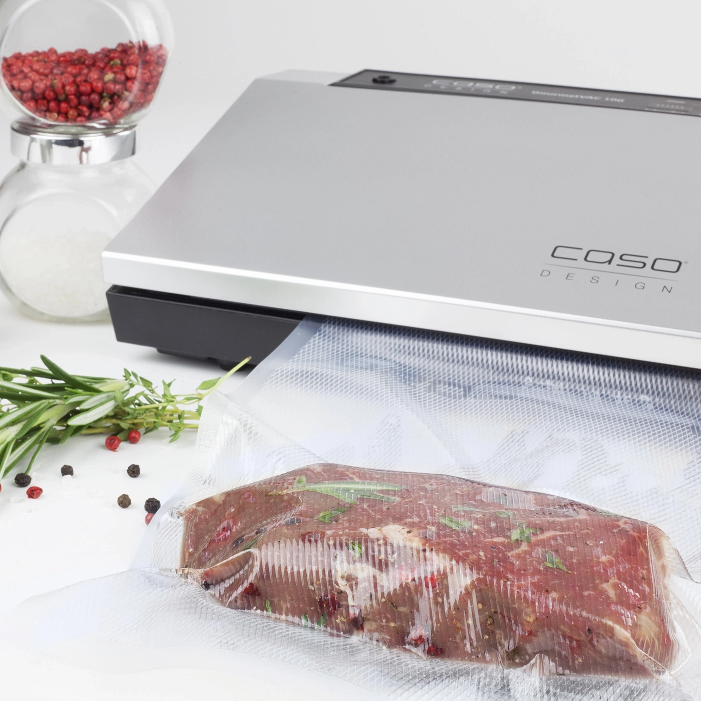 Meat in vacuum bag with spices and Caso Design vacuum sealer machine