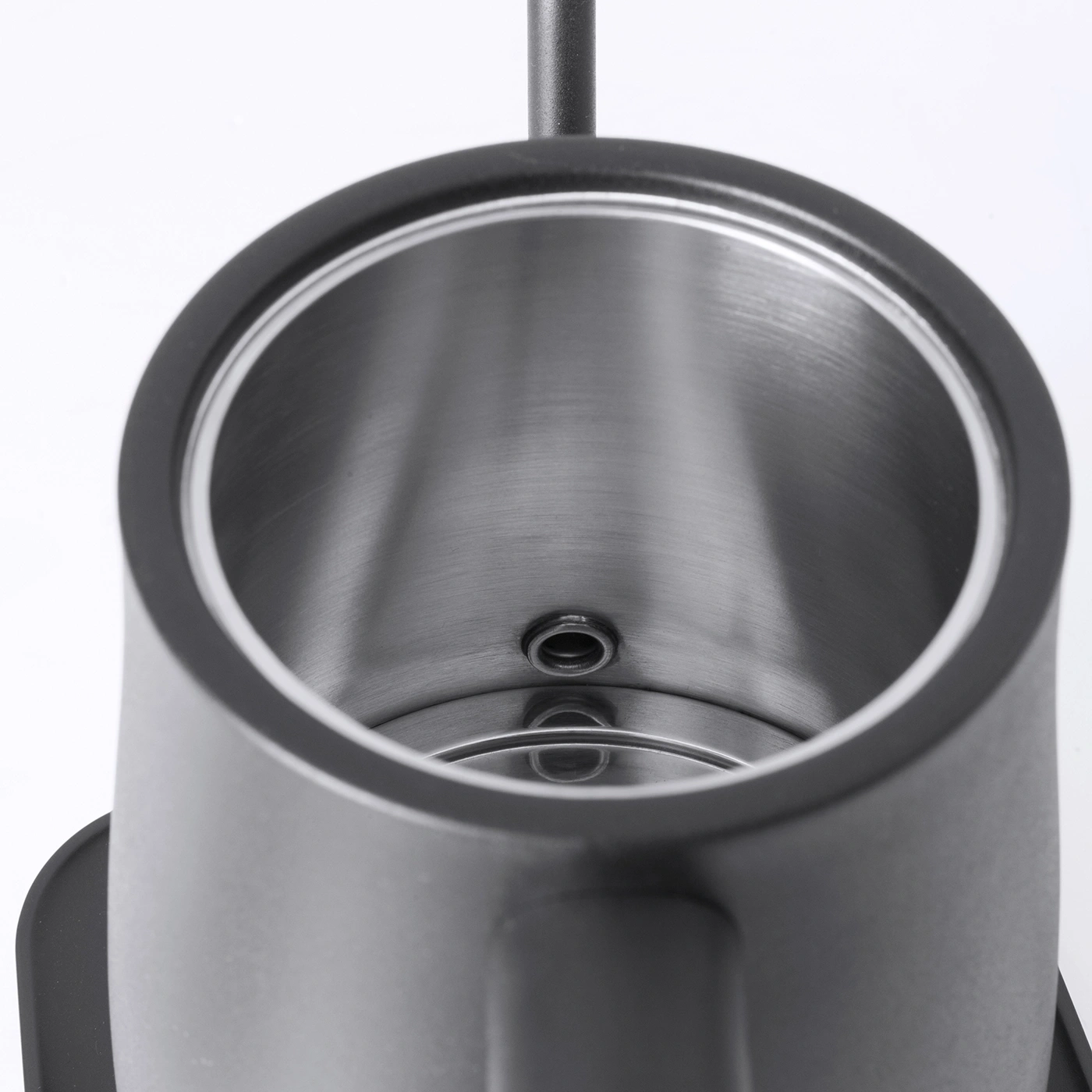 Nahaufnahme eines silbernen Wasserkochers mit schwarzem Griff und Deckel, Innenansicht