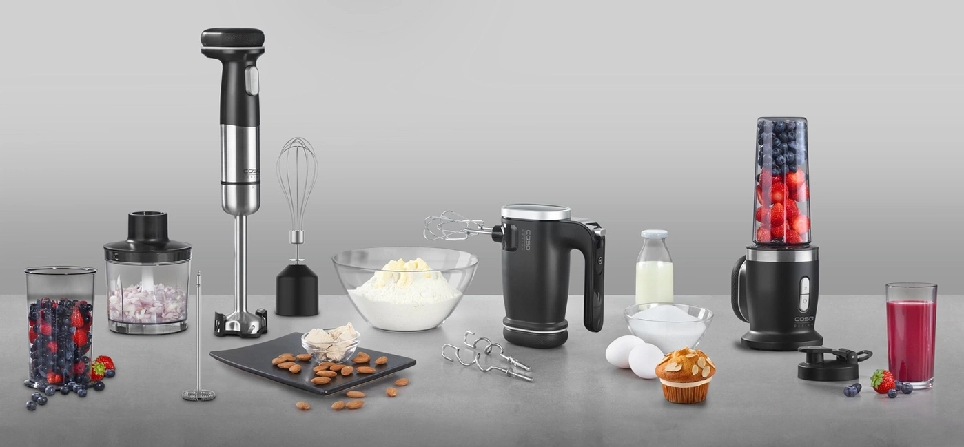 Kitchen appliances and ingredients for preparing food and drinks on a table.