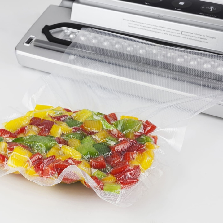 Peppers in vacuum packaging with a vacuum sealer on a white background