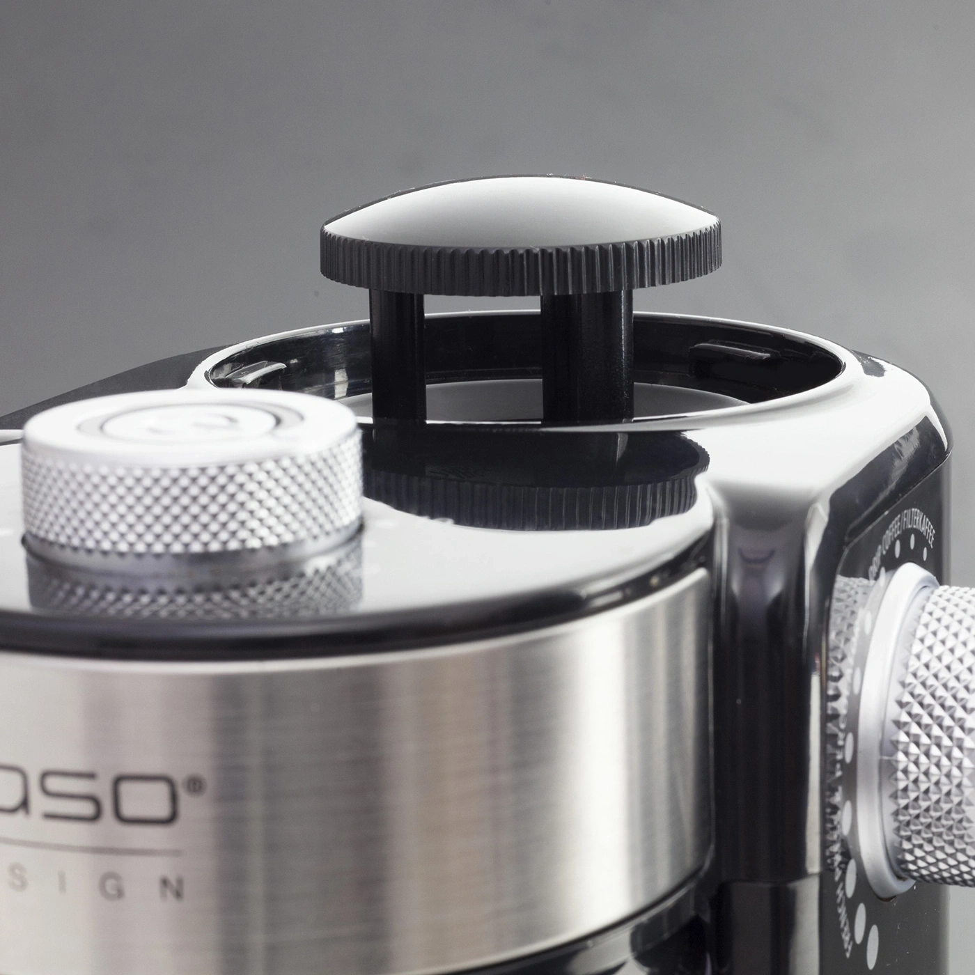 Close-up of a black coffee grinder design with silver accents and knobs.