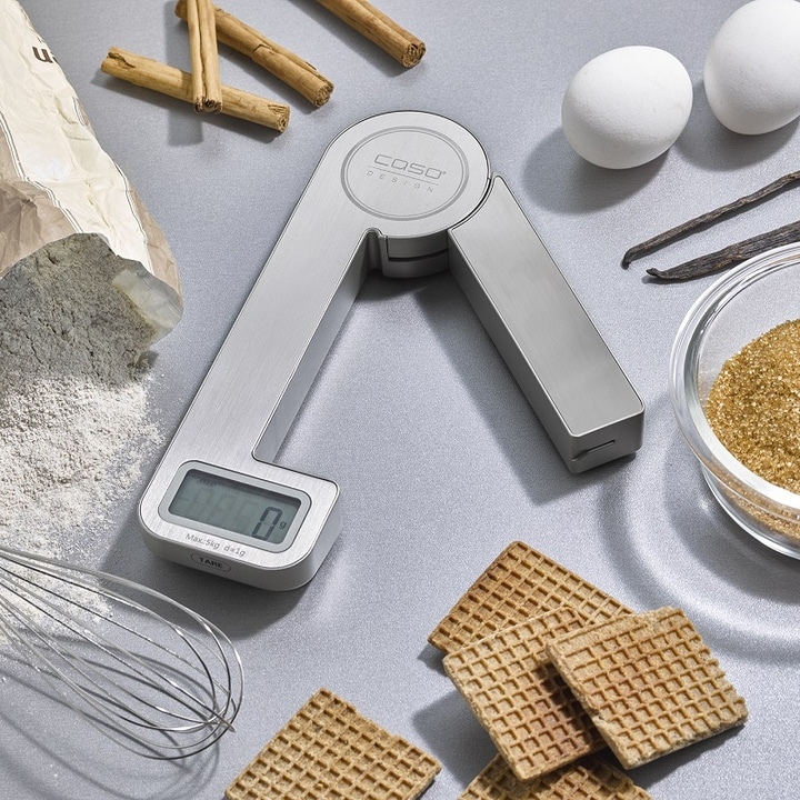 Kitchen scale with baking ingredients, cinnamon, eggs, sugar, waffles