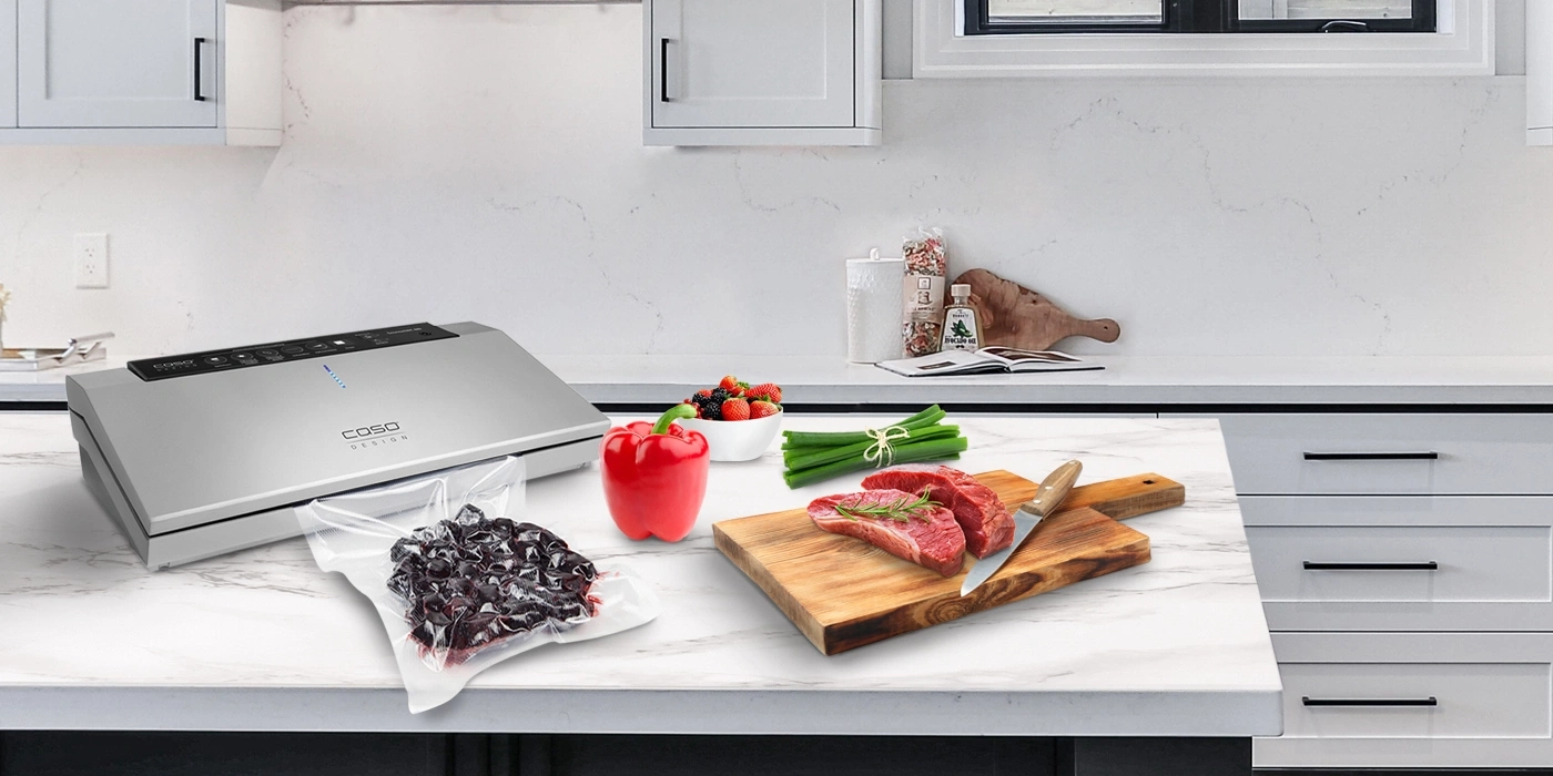 Kitchen scene with vacuum sealer, meat, vegetables, and fruits on a countertop